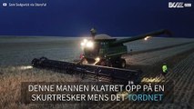 Mann danser på toppen av en skurtresker mens det tordner