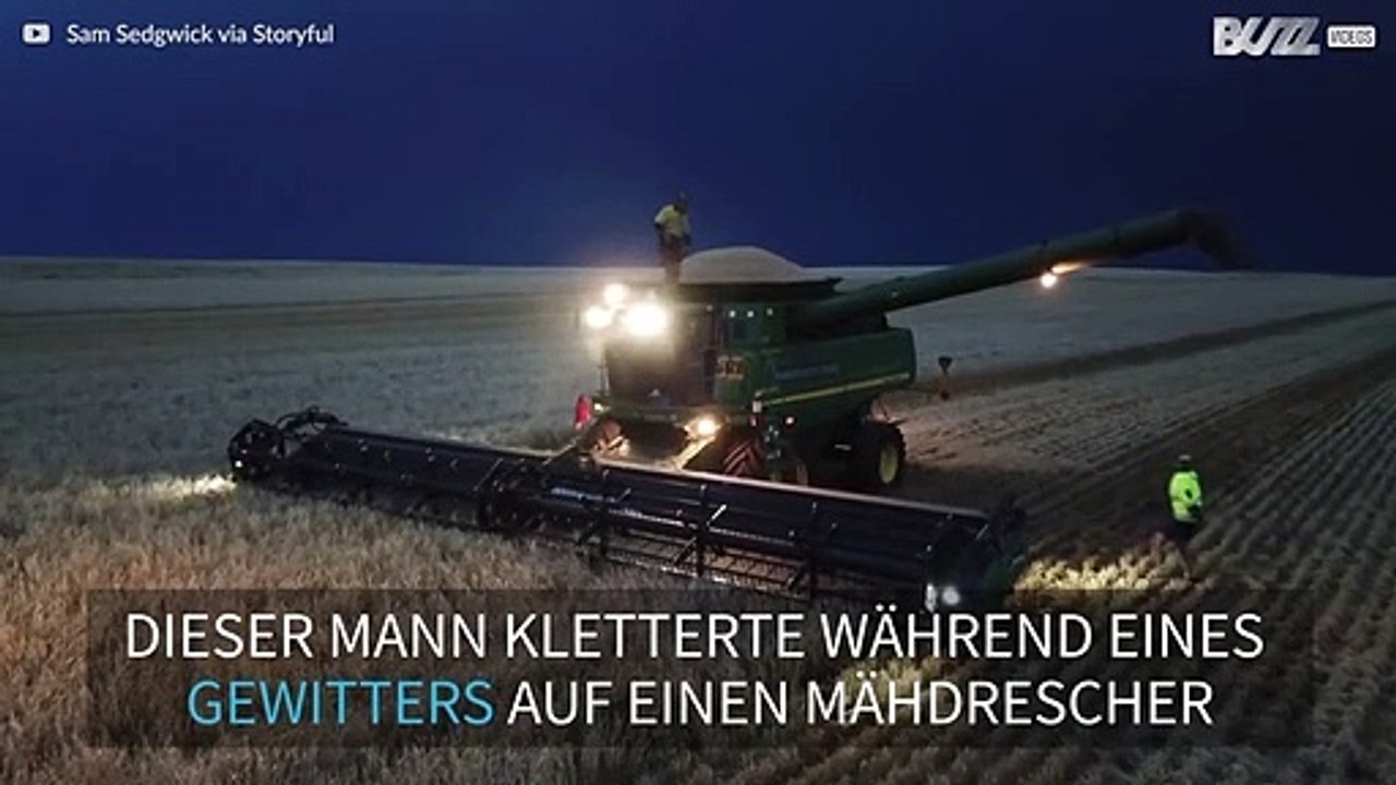 Mann tanzt auf Mähdrescher während es gewittert