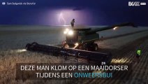 Man danst bovenop een maaidorser tijdens onweersbui