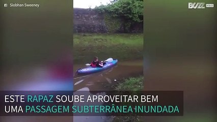 Rapaz diverte-se a andar de caiaque em rua inundada