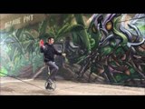 Man Sitting on Unicycle Juggles While Balancing on Slackline