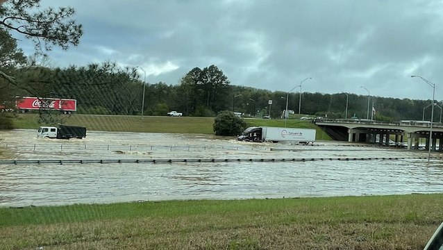 Trucks drive through flooded I-65 in Alabama
