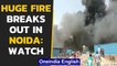 Noida: Several huts catch fire as huge fire breaks out near sector 63, reason unknown| Oneindia News