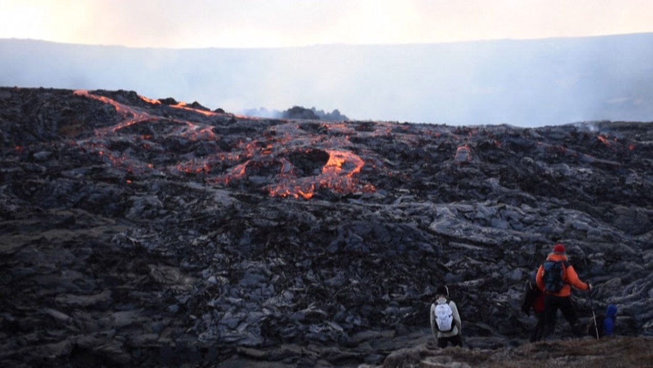 Guests watch as lava pours from volcano