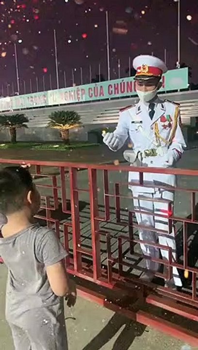 Chú bộ đội chỉnh tư thế chào cho cậu bé đáng yêu