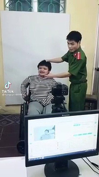 cán bộ có hành động dễ thương giúp người khuyết tật làm CCCD