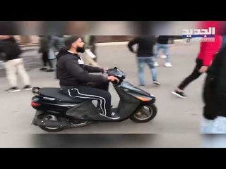 شبان يقتحمون ساحة الشهداء ويمزقون اللافتات ويحرقونها