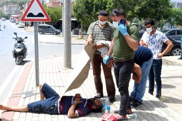 Kaza yapan sürücüyü kavurucu sıcaktan kartonla korudular