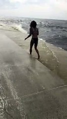 Lady Posing for Picture Surprised by Big Wave