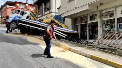 Ümraniye'de park halindeki otomobile çarpan kamyon binanın bahçesine devrildi