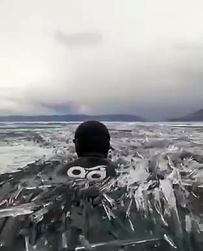 Il nage dans le lac Baïkal et c'est impressionnant.. et glacial