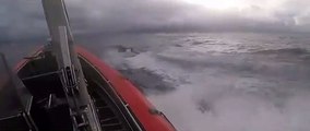 Des garde-côtes sautent sur un sous-marin en mouvement en pleine mer