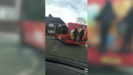 Shocking video shows two school boys risking their lives clinging onto the back of a moving bus