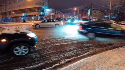 Busy crossroads during snowy night.