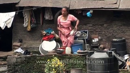 Woman washing utensils in the capital of Nepal- Kathmandu