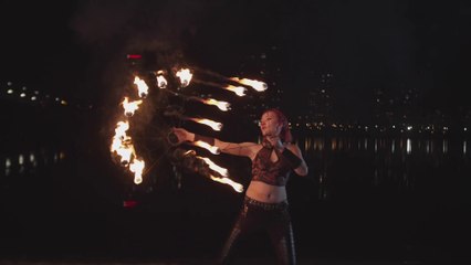 Bold and beautiful woman doing fire stunt energetically 