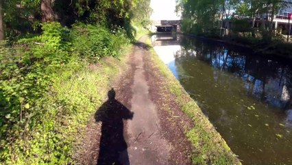 Deux cyclistes se rencontrent sous le pont d'un canal