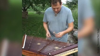 Un homme joue sur un "hackbrett"