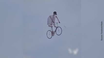 Un homme cerf-volant sur un vélo