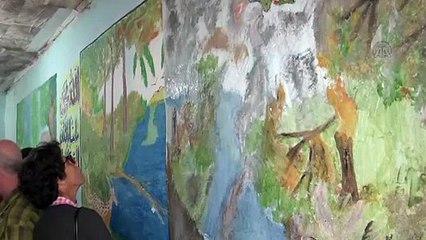 Suriye'de yaşananları evinin duvarlarına resmetti