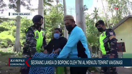 Seorang Lansia Dibopong Oleh TNI AL Menuju Tempat Vaksinasi