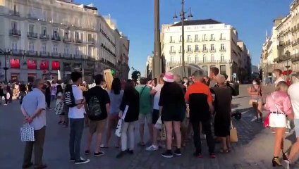 Un grupo de gente se acerca a Antonio López mientras pinta en la Puerta del Sol