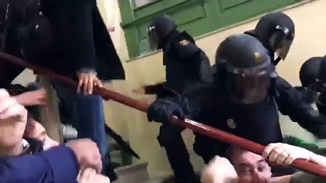 Policies nacionals tirant noia per l'escala, carrer Pau Claris