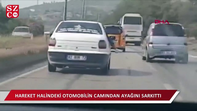 Hareket halindeki otomobilin camından ayağını sarkıttı