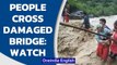Uttarakhand: People cross a temporary bridge damaged due to heavy rainfall| Dehradun| Oneindia News