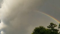 Massive storm cloud rolls away to reveal double rainbow