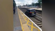 Commuters watch in horror as stolen Range Rover drivers down rail tracks at busy station