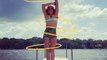 Circus Artist Spins Multiple Hula Hoops on Her Body While Rotating At Pier