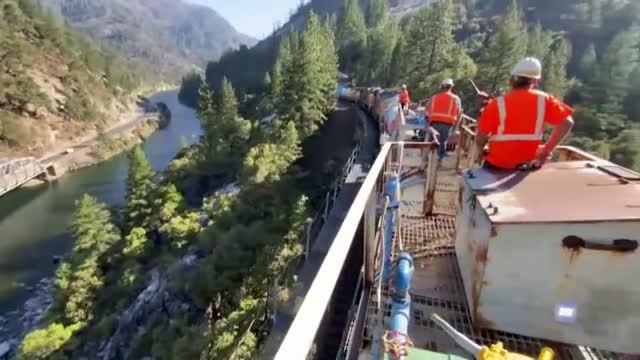 Los bomberos de EEUU apagan las llamas desde un tren en marcha