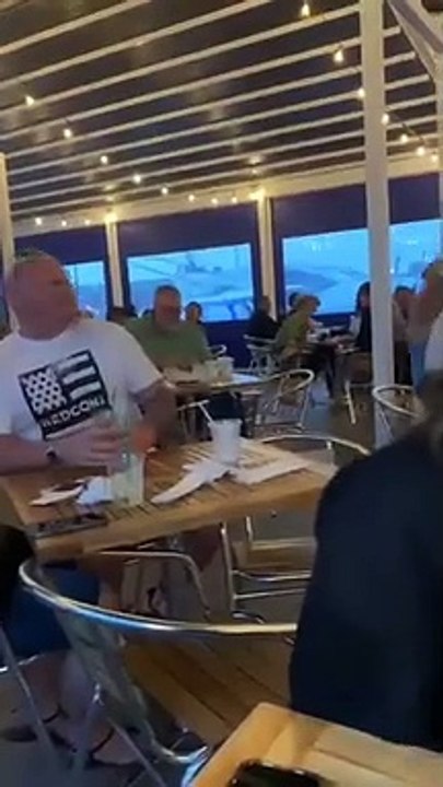 Ce petit garçon fait rire toute la salle de ce restaurant en levant les bras