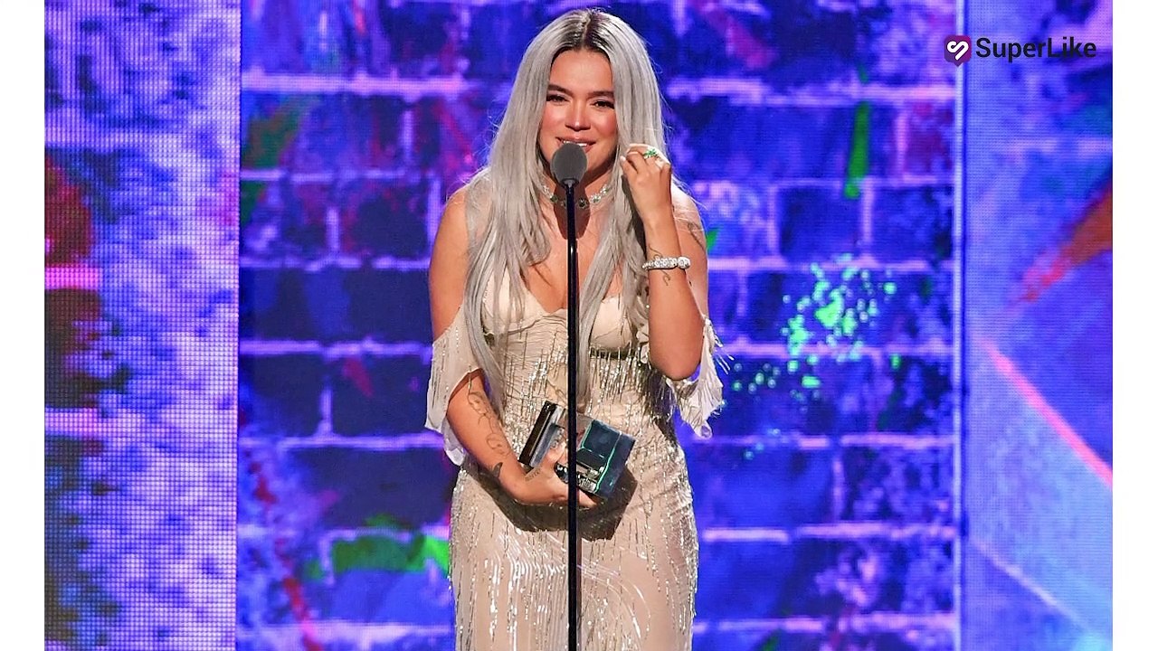 El detrás de cámaras de show de Karol G donde varias personas cargaban su vestido