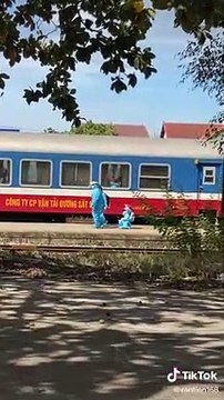 Hình ảnh cô gái nhỏ trong bộ đồ bảo hộ được chú cán bộ ân cần chăm sóc