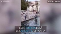 Turista salta para uma estátua em Alicante, Espanha
