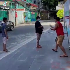 Người đàn ông cúi người khi tặng tiền cho bà con