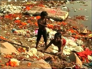 Polio afflicted rag picker near the filth of Yamuna river