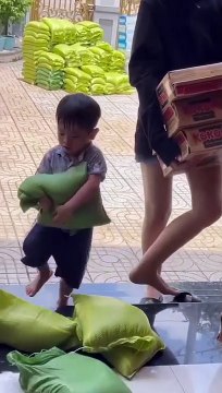 Bé trai góp sức bê gạo giúp đỡ người nghèo mùa dịch