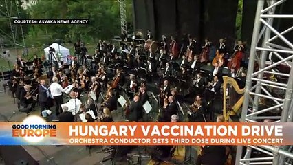 Hungarian conductor promotes vaccination by receiving a jab while performing
