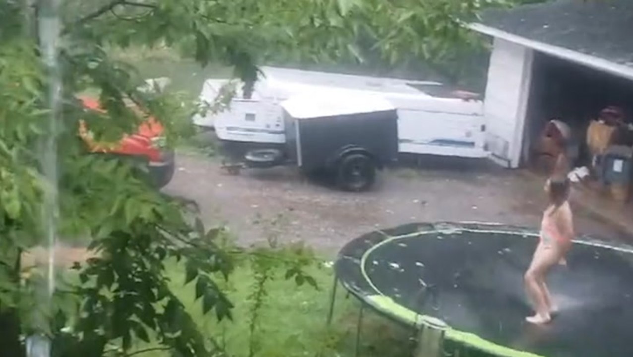 Storms don't keep this child away from the trampoline