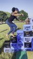 Woman Climbs Milk Crates Arranged Like Stairs Wearing Heels