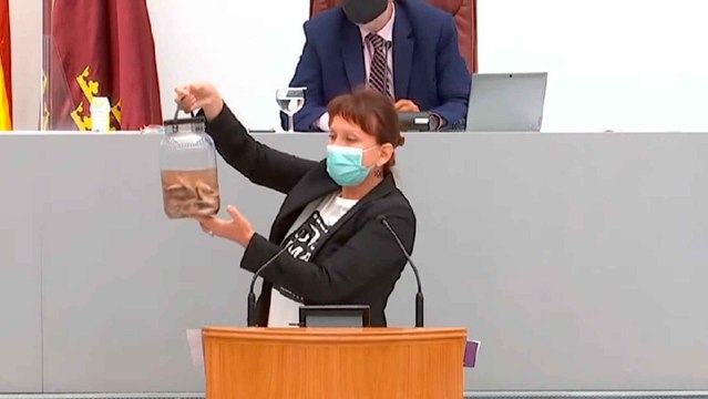María Marín, portavoz de Unidas Podemos, mostrando peces muertos del Mar Menor en la Asamblea.