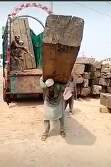 Man  carries massive wooden pillar