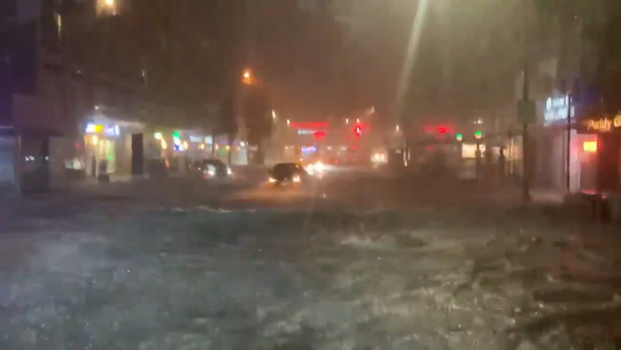 Passengers stand on seats as bus navigates flooded road