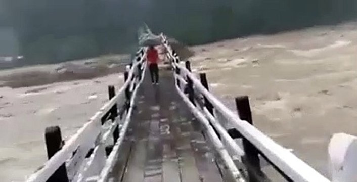 Ils traversent un pont piéton en pleine crue... Risqué et terrifiant