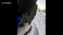 Un alpiniste marche sur la crête d'une montagne et c'est vertigineux