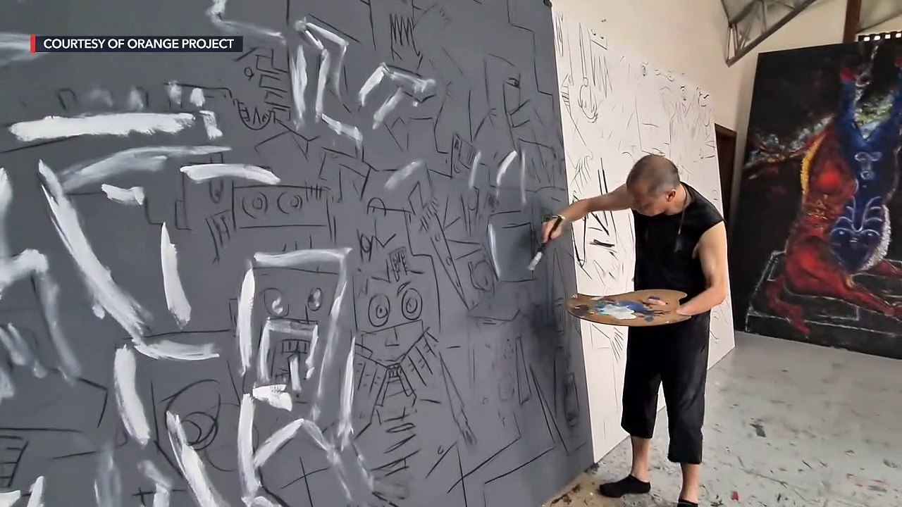 Visual artist Charlie Co working on his piece, 'World Gone Mad'
