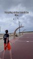 Guy Tries to Score Basket on the Beach Basketball Court but Strong Winds Blow the Ball Away